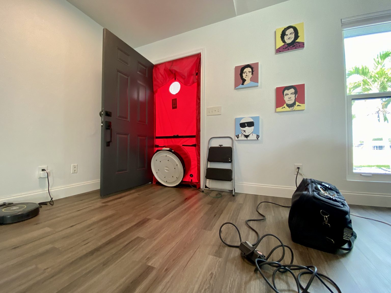 A picture of the doorway with a blower door test attached in our attainable net zero energy solar home. The door is opened with the testing machine creating an airtight seal and a fan inside it.