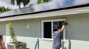 A picture of the window installer drilling screws into the frame of our new Energy Star hurricane impact windows on our net-zero solar energy home.