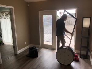 Photo of an energy auditor removing an exterior door from our first net-zero home in preparation to perform a blower door test.