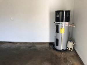 Photo of the heat pump water heater in the corner of the garage of the First Attainable Home