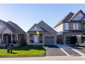 Photo of houses in a subdivision with a yellow arrow pointing out an exterior attic vent to highlight the difference between a vented or unvented attic.