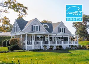 Photo of a beige frame house with white porch rails and a green grass lawn with an energy star certification logo