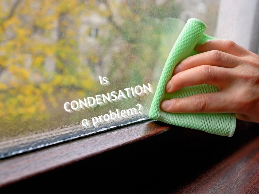 Photo of a hand holding a cleaning cloth wiping condensation off a window with the caption "Is Condensation a problem?"