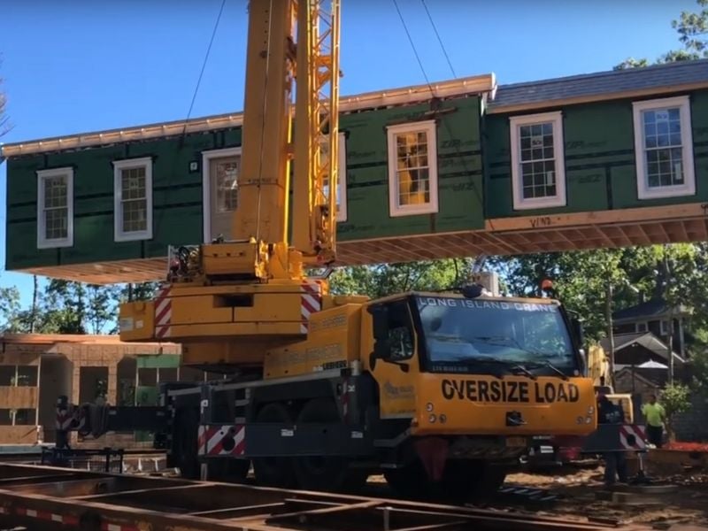 An image of a module being placed by a crane on a building site operated by Cedar Knolls Homes.