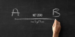 Photo of a hand drawing a line from an A to a B on a blackboard with the caption "Net Zero: How to get there."