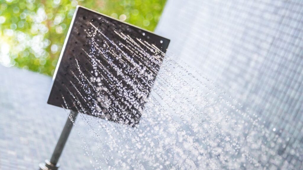 A picture of a square shower head above the camera, with hot water flowing through it.