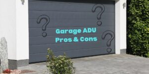 Photo of a gray garage door on a cream colored house next to a green hedge with the caption "Garage ADU Pros & Cons"