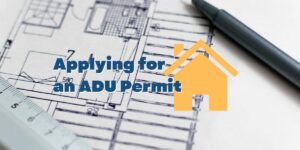 Photo of an architect's blueprint with a pen and the caption "Applying for an ADU Permit"