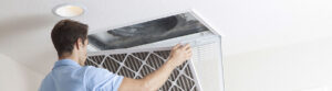A professional installing a filter to prevent air duct leakage