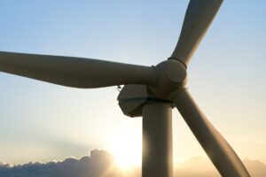 A closeup on a small wind turbine with a sunset in the background