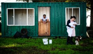 family in front of their container home