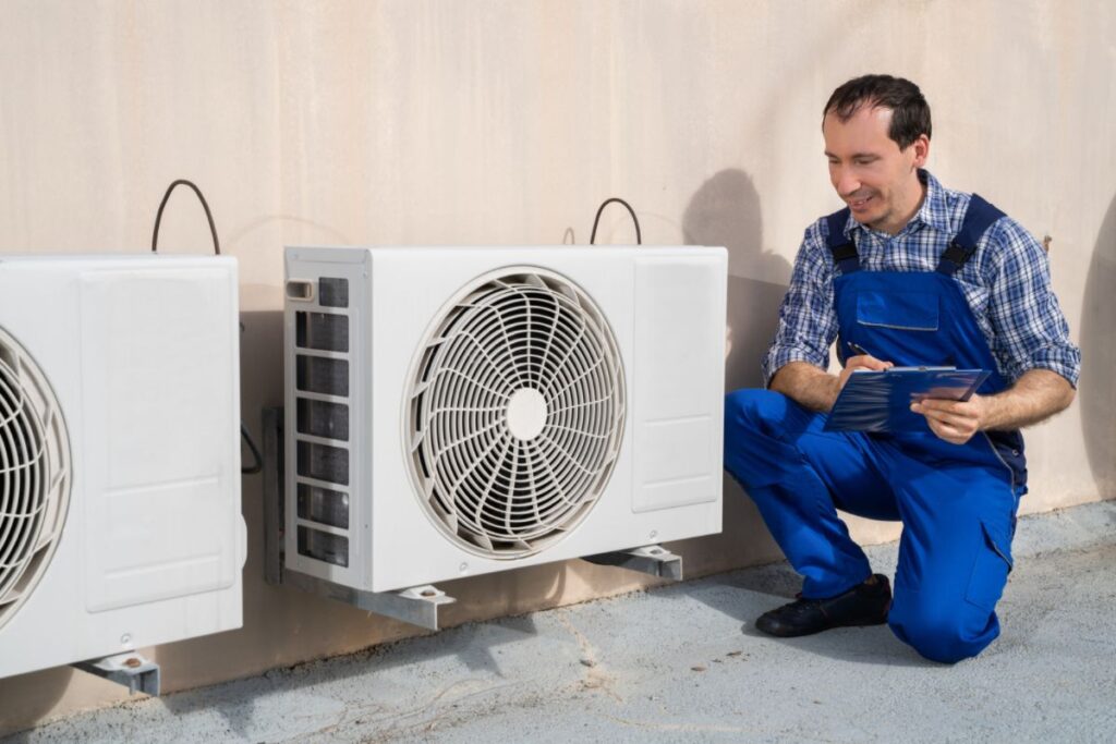 A technician checks the status of an energy recovery ventilator