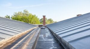 A peaks of a metal cool roof on top of a building are shown on either end