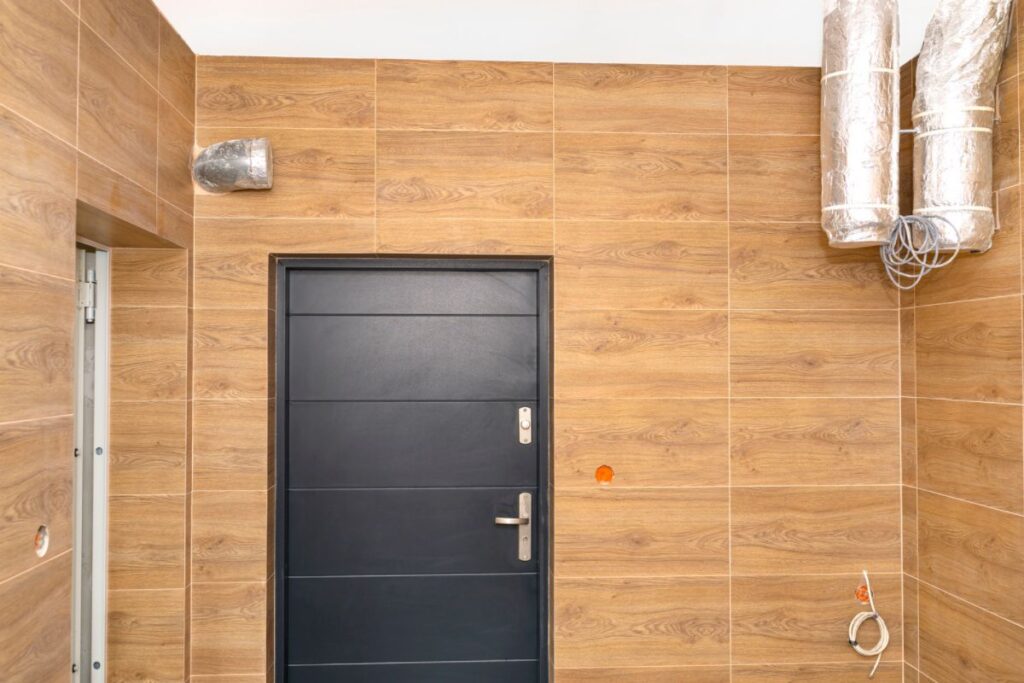 The wall of a room with HRV ductwork in the corner near the ceiling is depicted
