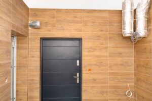 The wall of a room with HRV ductwork in the corner near the ceiling is depicted