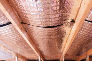 A radiant barrier runs along the ceiling of an attic in a home