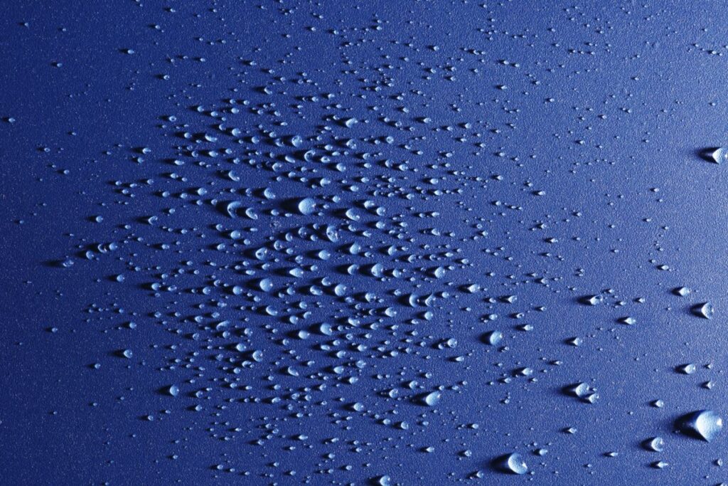 moisture in the form of water droplets on a blue substrate
