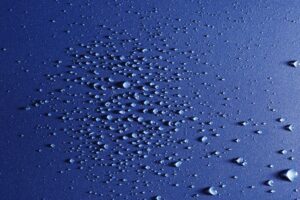 moisture in the form of water droplets on a blue substrate