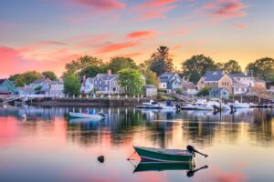 A view of a fishing boat on the New Hampshire waterfront in the foreground and several homes in the background