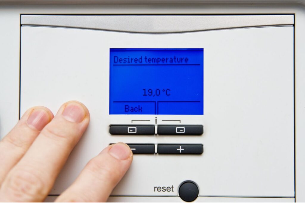 A homeowner adjusts the settings on the interface of their energy recovery ventilator system
