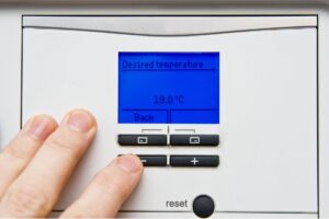 A homeowner adjusts the settings on the interface of their energy recovery ventilator system