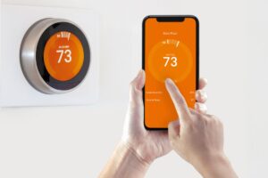A homeowner adjusts the settings on their smart thermostat from their smartphone.
