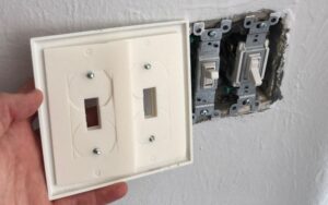 outlet cover insulation sealers being installed in a wall to prevent air leakage