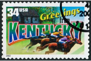 A retro stamp depicting horses and jockeys racing in the foreground transposed above the text "Greetings from Kentucky"