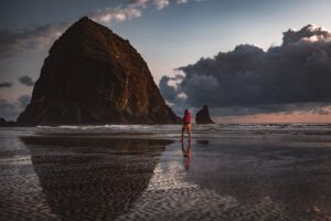 A man dipping his toes into the pristine waters of the Oregon coast