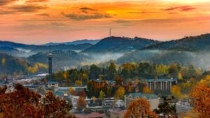 A view of a sleepy Tennessee town at sundown during the Fall, with fog submerged below the mountains