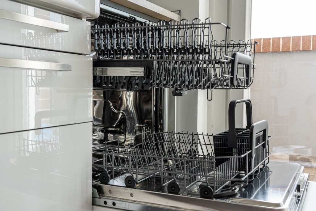 Closeup view of an open dishwasher in a kitchen