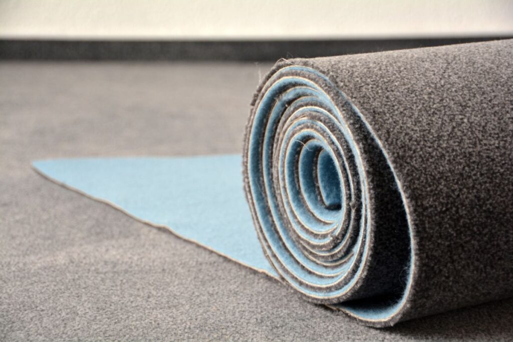 Closeup on the end of a roll of polyester carpet on a floor