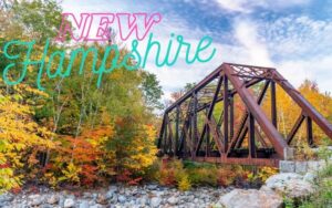 foliage changing colors in Fall in back of an old bridge over a stream in New Hampshire