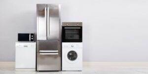 An appliance package pictured together up against the wall of a home, including a washer, dryer, and fridge