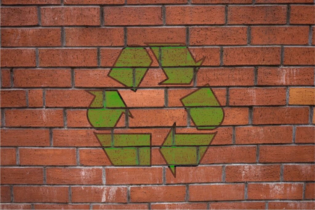 The recycling emblem painted on a brick wall