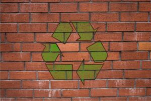 The recycling emblem painted on a brick wall
