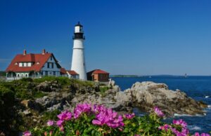 A green home and lighthouse along the Maine coastline