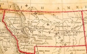 a tan and red map outlining the state of Montana in old fashioned text