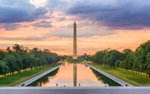 the washington dc monument at dusk reflecting across the water
