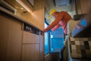 An RV owner reaches into an RV fridge in his unit