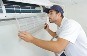 A homeowner installing a wall-mounted mini-split air handler below the ceiling