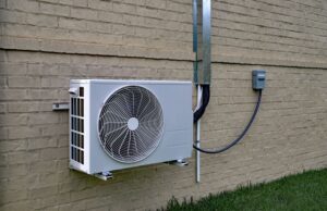 A ductless mini-split compressor on the external wall of a home