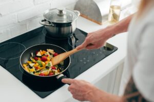 A homeowner cooks stir fry using an electric stove top