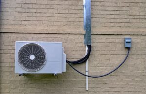 The exterior component of a ductless mini-split attached to a home's exterior brick wall