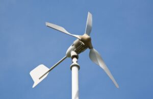 The rotor component of a small wind turbine and blue sky in the background