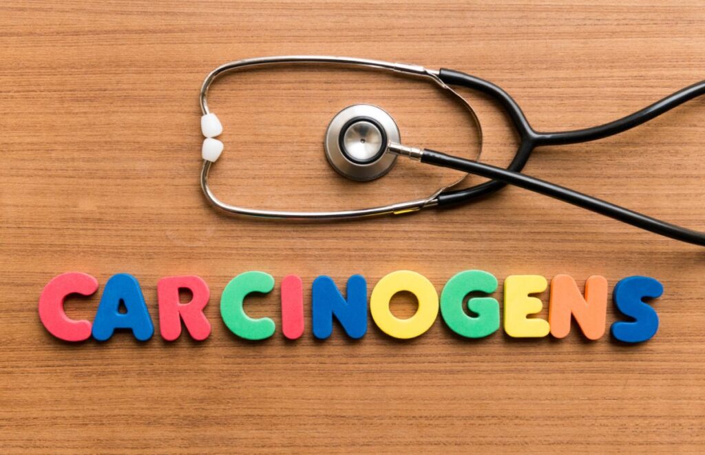 A tabletop with a stethoscope above magnet letters spelling out 'carcinogenic'