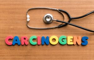A tabletop with a stethoscope above magnet letters spelling out 'carcinogenic'