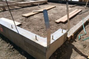 The foundation of a house with hurricane strap plates fashioned to it vertically