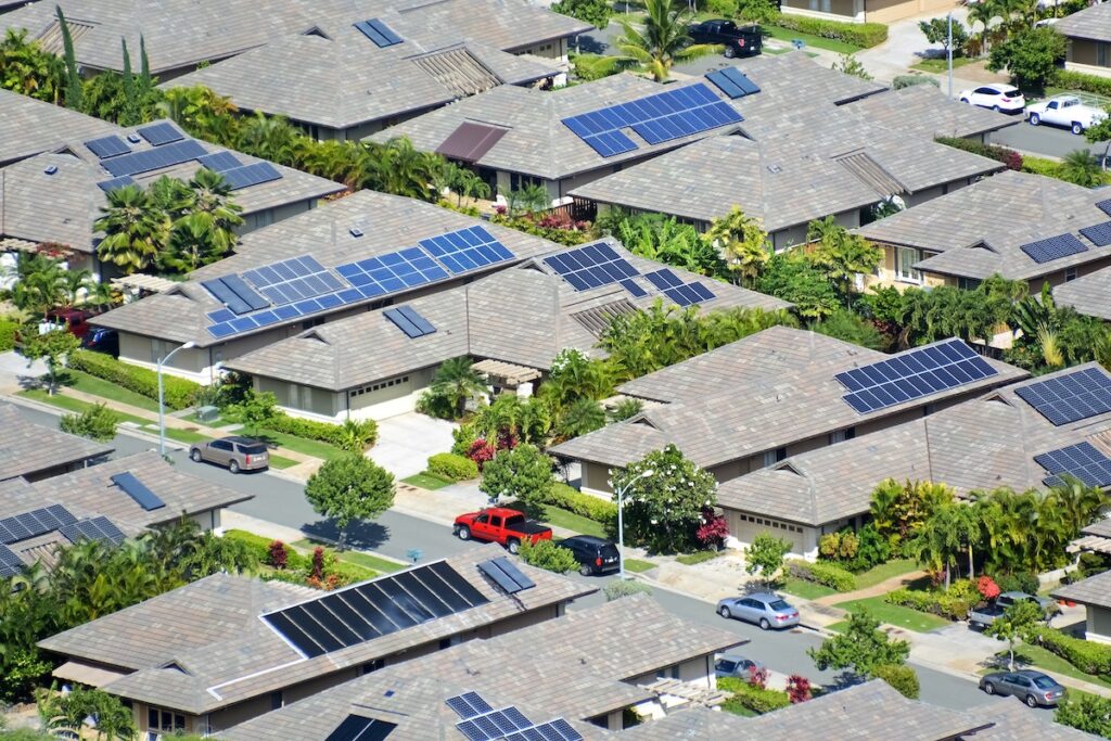 Arial shot of a residential neighborhood with solar panels installed on roofs of the net-zero homes