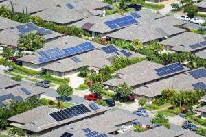 Arial shot of a residential neighborhood with solar panels installed on roofs of the net-zero homes